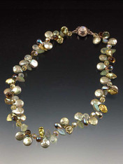 A delicate and dazzling collar of sage coin pearls, petal pearls, precious stones, tourmalated quartz, frosted glass leaves, and Swarovski crystals, with custom moonstone sterling clasp. Each made completely by hand so no two are identical. 17-1/2"