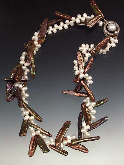 About six years ago I discovered several strands of bronze biwa pearls that were drilled at an unusual angle either intentionally or accidentally.  When entwined with tiny white freshwater pearls the effect is exactly like twigs with sprigs of white blossoms. Held with a vintage mabe pearl sterling clasp. You'll never see this again.  Only three! 17"