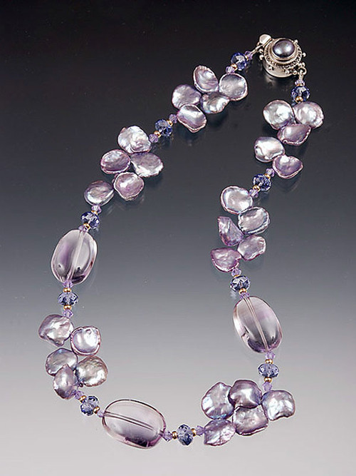 An extraordinary luscious collar of  lilac petal pearls spaced with  large Grade AAA lilac amethyst smooth nuggets, swarovski crystals and 14K.  A custom mabe pearl sterling clasp completes this gorgeous picture.  ONLY TWO!