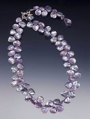 A dimensional collar of absolutely huge purple/blue  petal pearls gathered in a custom amethyst sterling toggle clasp with a dramatic 3" "lariat" dangle ending in a faceted lilac amethyst or iolite teardrop. Lariat looks smashing in the front or down the back of a low-cut dress.
