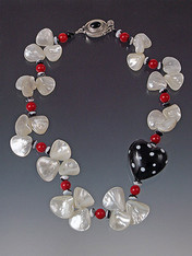 A whimsical black and white 1-1/4" puffed polka dot heart adds fun to any occasion. Glowing white mother of pearl fans, red coral beads and custom onyx sterling clasp complete the festive picture! 18" (ask about longer lengths)