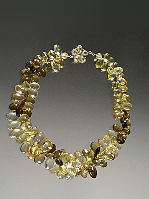 Many years ago I discovered this amazing strand of Grade AAA faceted gemstone quality multi-toned topaz briolettes shooting off sparks of lemon, olive, brown and other tones. I decided to kept this cluster together in a spectacular collar fit for a queen with a matching topaz silver custom clasp. 19"