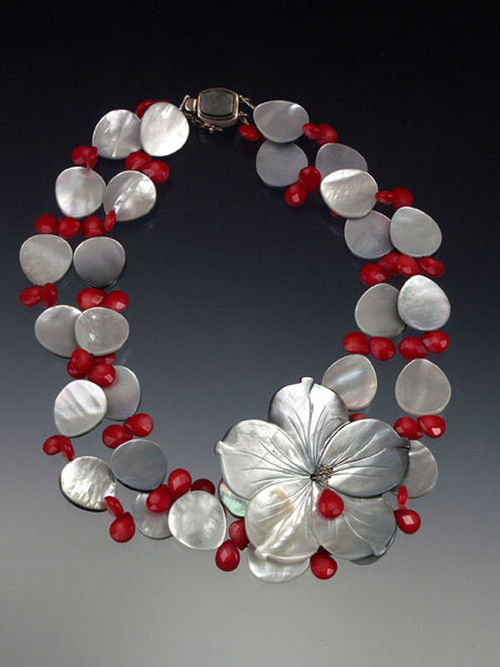 A carved black or white mother of-pearl flower on 2 strands.