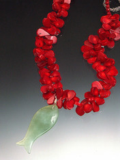 Hand-carved green jade fish floats gracefully on a 19" strand of red coral florets. 