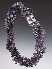 Opulent and gorgeous!  This dramatic torsade features faceted amethyst and iolite briolettes, peacock freshwater pearls and an iolite sterling custom clasp for a side or center highlight.   20"