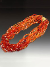 Definitely a VSOP (Very Special Occasion Piece).  Multi-strands of brilliantly gradient faceted fire agate and carnelian ovals and nuggets gathered into an extraordinary one of a kind hand-crafted cast 18K clasp that would sell for $600 today!  (1" x1")  18"