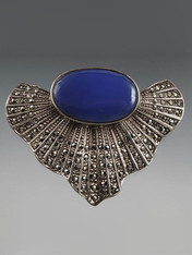 This dramatic pin is from the 1930s.  It features a large cobalt cabochon set in a beautifully detailed marcasite fan shape and sterling silver.  3" x 2"