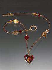 This one of a kind Venetian baby heart features 24K mingled with swirls of ruby, garnet and orange-gold on a bronze chain with tiny glass beads with Swarovski crystal stations.