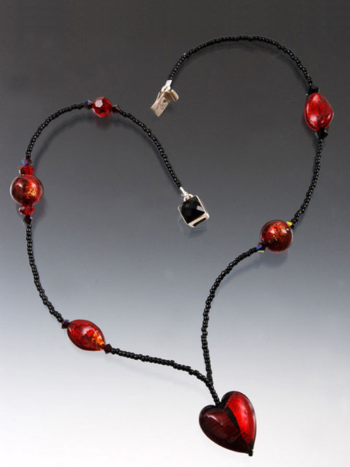 This delicate necklace features a ruby red and deep burgandy heart on a chain of tiny black glass beads with Venetian glass and Swarovski crystal. 17-1/2"
