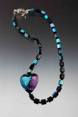 This dramatic statement necklace features a dichroic* venetian glass heart with flashes of purple, aqua, black, gold and green on a chain of vintage iridescent Czech glass faceted cubes spaced with Swarovski crystals.