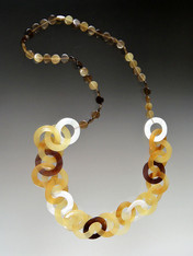 This lightweight on trend necklace features luminous natural makabibi shell,horn, and mother-of-pearl linked circles in tones of amber, tortoise, dark brown and white with smaller natural horn discs around the neck for extra comfort.  22" 
