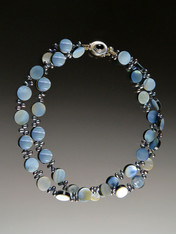 A blue by any other name could be denim, sky, cloud, azure or a host of other tones. Whatever the shade, it's the on-trend color of the season. This double strand iridescent mother-of-pearl coin necklace spaced with peacock navy freshwater pearls is right on trend and perfect for the coming season.  20"