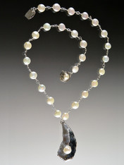 This spectacular necklace features silver-wire wrapped grade AAA white freshwater pearls and a sterling silver Oyster shell with a  perfect oyster pearl inside. Each unique pendant is hand-crafted in Bali. Necklace 18" Pendant 2"
 