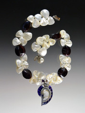 This dramatic limited-edition necklace features huge grade AAA mother-of-pearl fans, violet oyster 4-sided shells, and a one of a kind natural Indonesian sterling purple and white nautilus shell with a sterling freshwater pearl clasp. Necklace 18" Nautilus shell 3" 