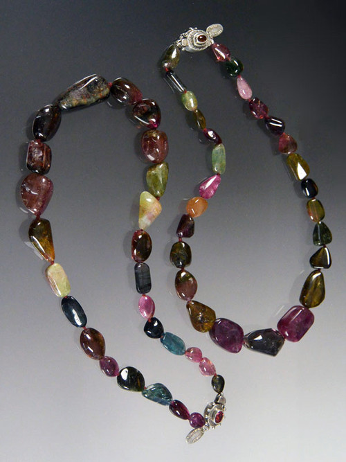 Tourmaline has skyrocketed in price in the past few years.  I have available two strands of smooth watermelon tourmaline pubble shapes ranging from deep wine to green to strawberry each hand-knotted with silk.  19"