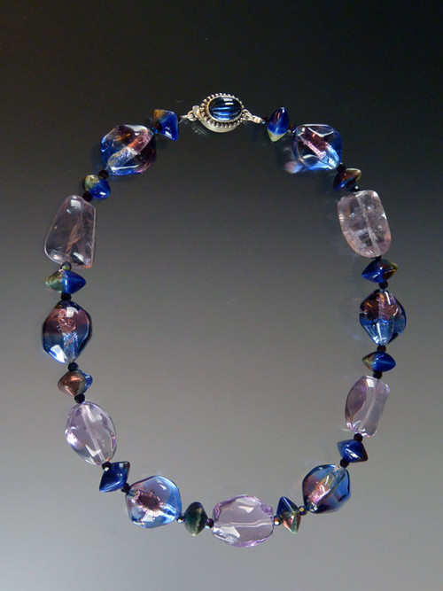 This magnificent statement necklace features Grade AAA lilac amethyst smooth clear pebbles, limited edition tri-color blue, purple, sterling silver Venetian sasso three dimension beads*, Greek ceramic midnight oil oxyhedron beads, swarovski crystals, and a vintage sterling blue clasp. 17-1/2  ONLY TWO!