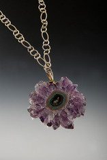 If you've ever explored caves, you've probably seen needle-like mineral formations called stalactites* hanging from the ceilings, walls or rising from the floor.  This particular specimen features purple amethyst with beautiful expanding circles of minerals formed over many years  This is so special that all it needs is a sparkling filigree sterling chain.  28"