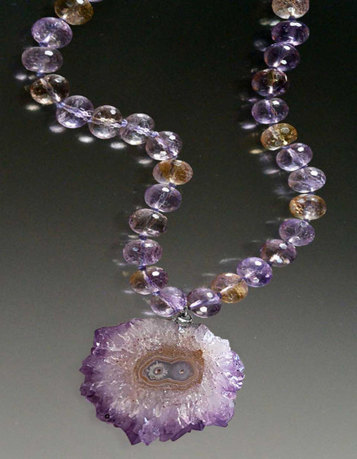 A gorgeous amethyst banded stalactite* pendant hangs from a collar of faceted grade AAA ametrine rondels.