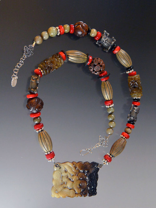 This piece is a real showstopper with a global vibe. The components are special pieces I've collected over the years. The highlight is a gorgeous piece of hand-carved multi-toned brown jade suspended from a strand of carved jade, red coral, Bali sterling silver, and Brazilian carved wood.  24"

 
