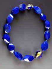 Fine lapis is becoming increasingly rare and expensive.  This one-of-a-kind statement necklace features grade AAA lapis faceted swirls with a 24K blue edged Venetian glass focal highlight and a lapis sterling clasp. 18"
