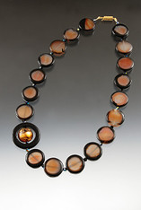 This very popular design is features subtle burnt orange agate rectangles with natural black trim spaced with jet Swarovski crystals feature a matte onyx donut centered with a 24K gold topaz Venetian glass disc.  Onyx sterling clasp 19" Choose rectangles or ovall beads.