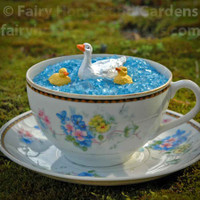 Miniature Duck and Duckies Shown Paddling in a Teacup