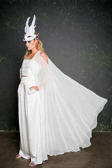 Add the Valentim cape to any House of Ollichon piece to create a striking, modern spin on the traditional veil. This stunning draped cape is made from silk chiffon providing an illusion over layer. You can wear the Valentim in three ways; cold-shoulder,Sherlock cape, or slung around the elbows.