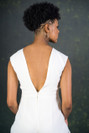 A structured bridal jumpsuit with a cinched-in waist and wide trouser legs. The cut-out sides and 80s themed shoulder shape will give any wedding day a touch of attitude.